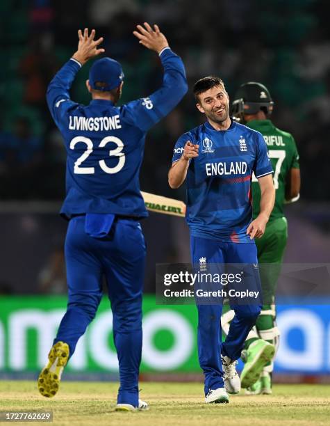 Mark Wood of England celebrates towards teammate Liam Livingstone after bowling Shoriful Islam of Bangladesh during the ICC Men's Cricket World Cup...