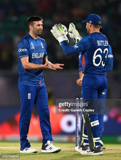 Mark Wood of England celebrates with teammate Jos Buttler after bowling Shoriful Islam of Bangladesh during the ICC Men's Cricket World Cup India...