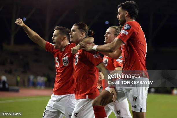 Austria's midfielder Marcel Sabitzer celebrates with teammates after scoring the opening goal from the penalty spot during the UEFA Euro 2024...