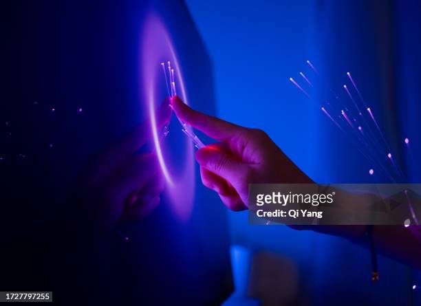 optical fiber wrapped around hand touching computer screen - viollet creative selects stock pictures, royalty-free photos & images