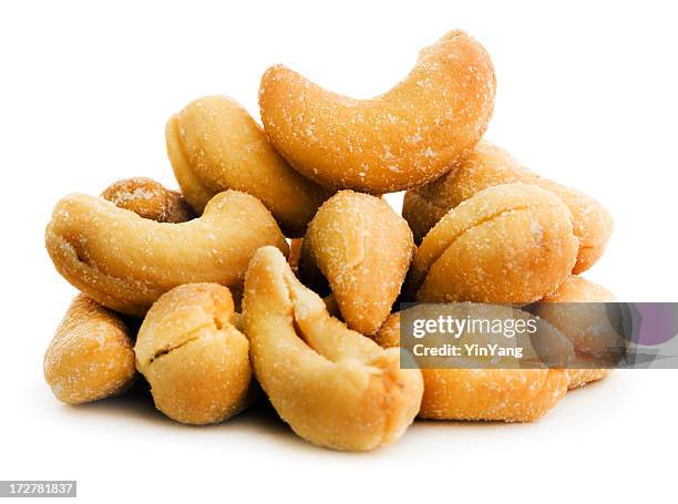 roasted cashew nuts, a salted snack stack isolated on white - cashew stock pictures, royalty-free photos & images