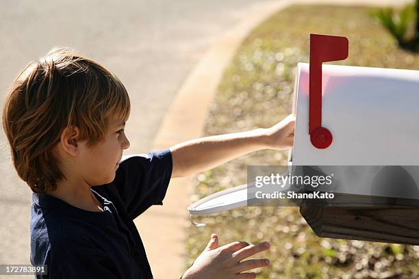 cute young boy drops off mail in mailbox - picking up mail stock pictures, royalty-free photos & images