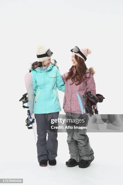 young japanese women wearing snowboard wear on white background - friends with white background stock pictures, royalty-free photos & images