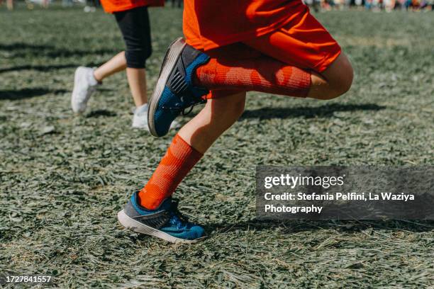 low section of children running - female muscular calves stockfoto's en -beelden