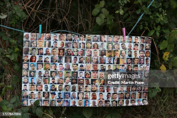 Sign showing portraits of those killed in Gaza and the West Bank hangs on a make-shift washing line outside the factory on October 16, 2023 in...