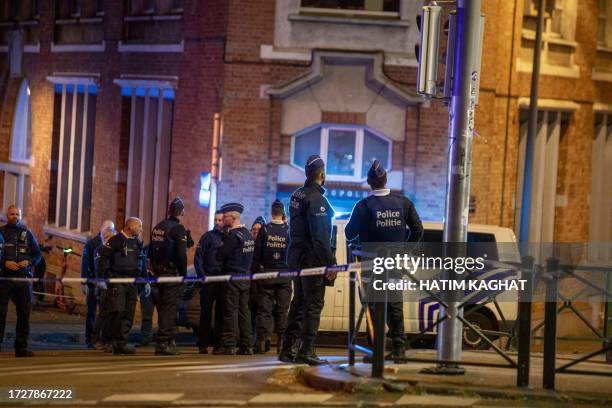 Belgium police stand at the site of a shooting incident in the Ieperlaan - Boulevard d'Ypres, in Brussels, on October 16, 2023. Two people were...