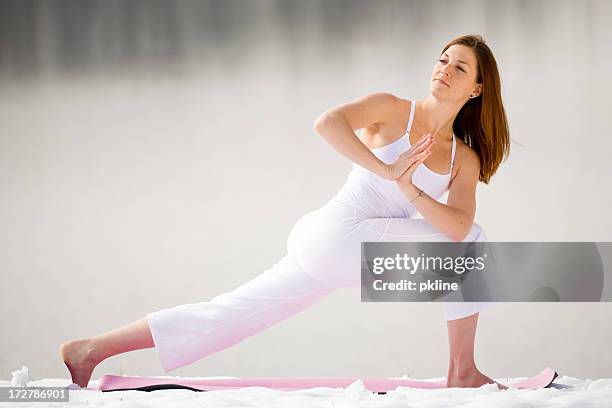 woman doing yoga pose in the snow - barefoot snow stock pictures, royalty-free photos & images