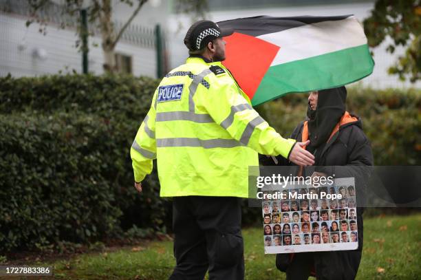 Police officer stops a protester impeding staff turning onto the main road on October 16, 2023 in Leicester. Pro-Palestinian protesters are...