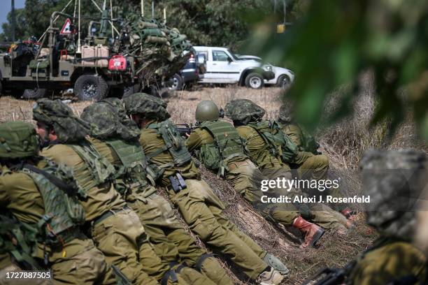 Soldiers wait in a trench, ready to fire, near the border with Gaza, on October 10, 2023 in Kfar Aza, Israel. Israel has sealed off Gaza and...