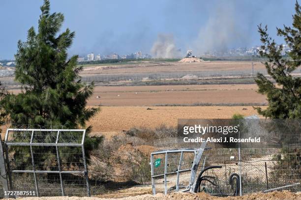 Smoke rises in the distance from Gaza near the spot where Hamas militants broke through the kibbutz Kfar Aza's fence days earlier, in a attack on...