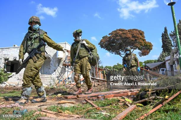 Soldiers point to the body of a Hamas militant who was killed days earlier after attacking this kibbutz near the border with Gaza, on October 10,...