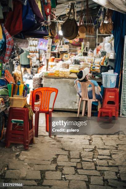 vietnamesische frau macht ein nickerchen am stand auf dem straßenmarkt in hue, vietnam - vietname stock-fotos und bilder
