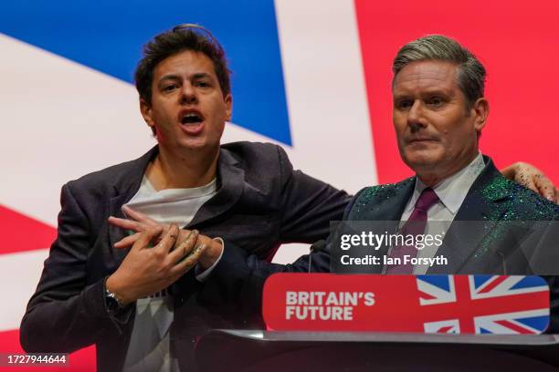 Protestor storms the stage and throws glitter over Labour party leader, Sir Keir Starmer during the leader's speech on the third day of the Labour...
