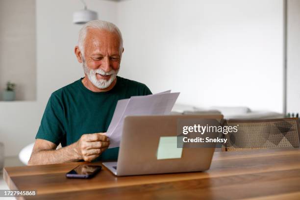 senior man using his laptop - invoice stock pictures, royalty-free photos & images