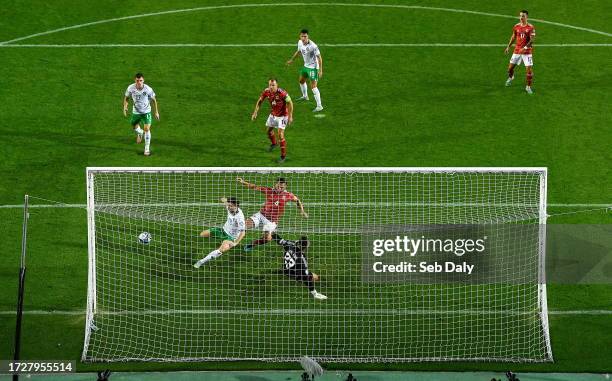 Algarve , Portugal - 16 October 2023; Mikey Johnston of Republic of Ireland scores his side's second goal despite the attention of John Sergeant of...