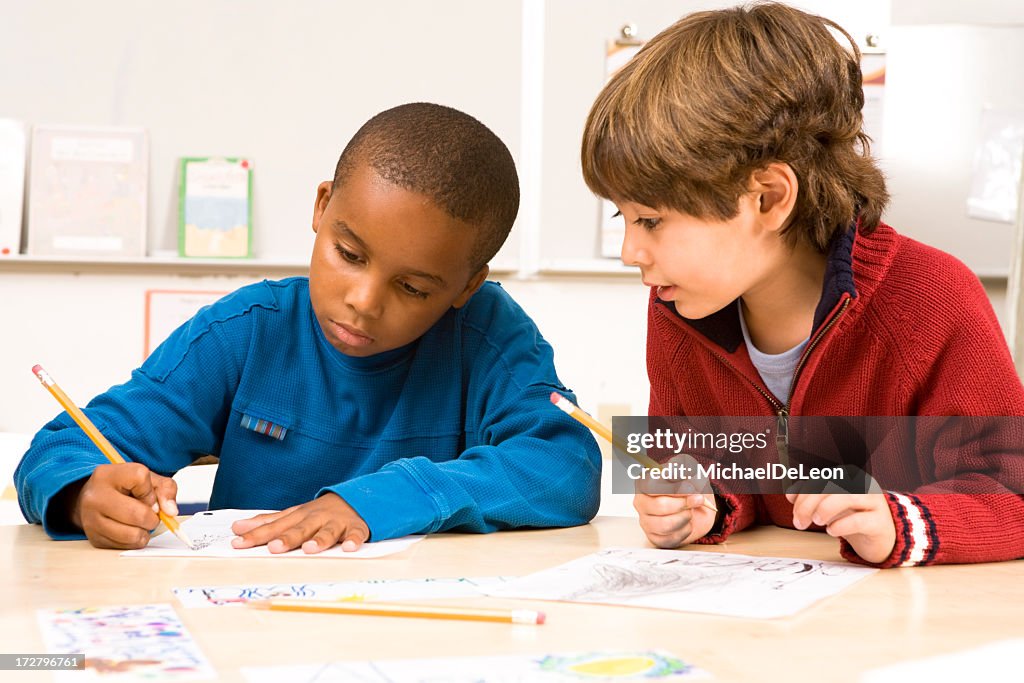 Two cute school boys doing homework together