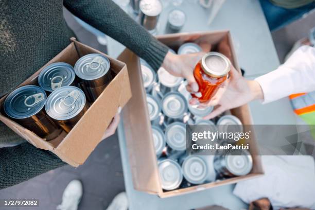 group of young volunteers helping the neighborhood and packing donation boxes - canned food drive stock pictures, royalty-free photos & images