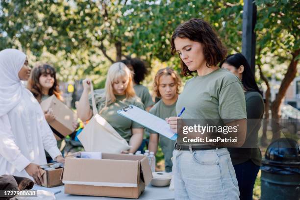 community services, young team of people helping the local community - clipboard stock pictures, royalty-free photos & images