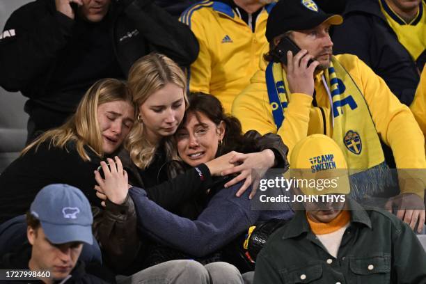 Swedish supporters react as they wait in the stand during the Euro 2024 qualifying football match between Belgium and Sweden at the King Baudouin...