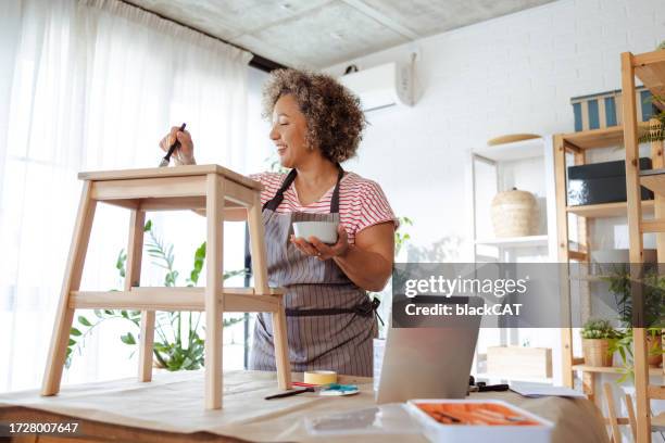 mujer madura restaurando una silla vieja - incompleto fotografías e imágenes de stock