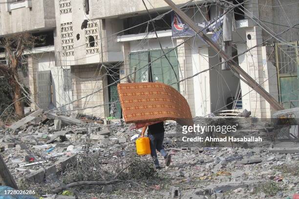 Palestinian citizens evacuate their homes damaged by Israeli airstrikes on October 10, 2023 in Gaza City, Gaza. Almost 800 people have died in Gaza,...