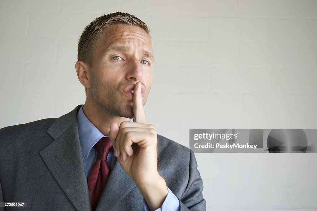 Shhh! Businessman Holding Finger to His Lips