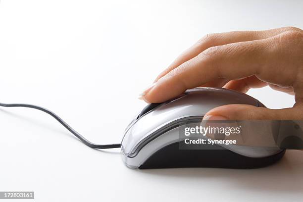 a woman's hand navigating a mouse - hand on computer mouse stock pictures, royalty-free photos & images