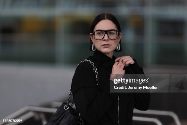 Maria Barteczko is seen wearing large black Aviator glasses from Victoria Beckham, silver oval-shaped earrings covered with rhinestones from Céline,...