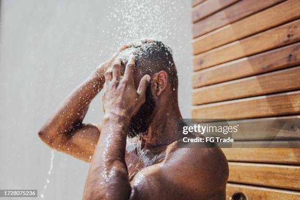 mid adult man taking a shower outdoors - washing hair stock pictures, royalty-free photos & images