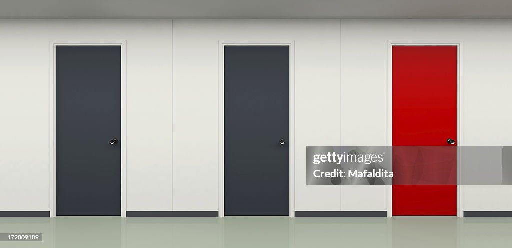 Two black and one red door in office corridor