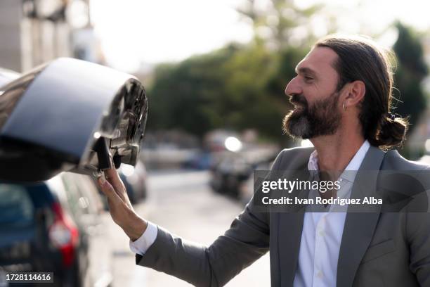 businessman closes the boot of his car - closing car boot fotografías e imágenes de stock