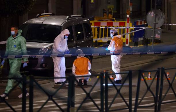 Belgian police officers from the forensic service search for evidence in a street after two people were killed during a shooting in Brussels on...