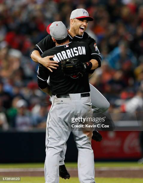 Placido Polanco of the Miami Marlins celebrates with Logan Morrison after their 4-3 win in the ninth inning over the Atlanta Braves at Turner Field...