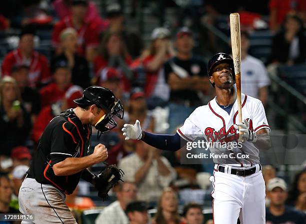 Jeff Mathis of the Miami Marlins celebrates their 4-3 win as B.J. Upton of the Atlanta Braves reacts to striking out to end the ninth inning at...