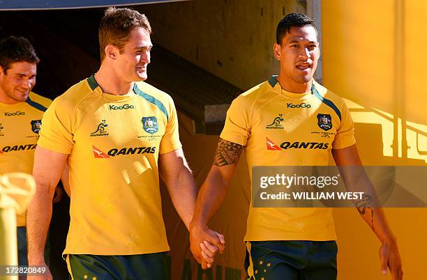 Australian Wallabies rugby players captain James Horwill and winger Israel Folau hold hands as they come out for the Captain's Run training session...