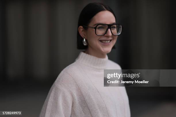 Maria Barteczko is seen wearing large black Aviator glasses from Victoria Beckham, silver earrings in drop shape from Bottega Veneta and an off white...