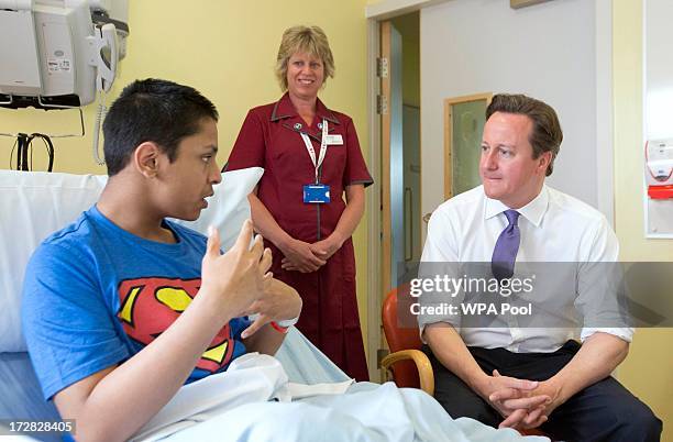 Prime Minister David Cameron speaks with patient Liam Islam during his visit to the Evelina London Children's Hospital on July 5, 2013 in London,...