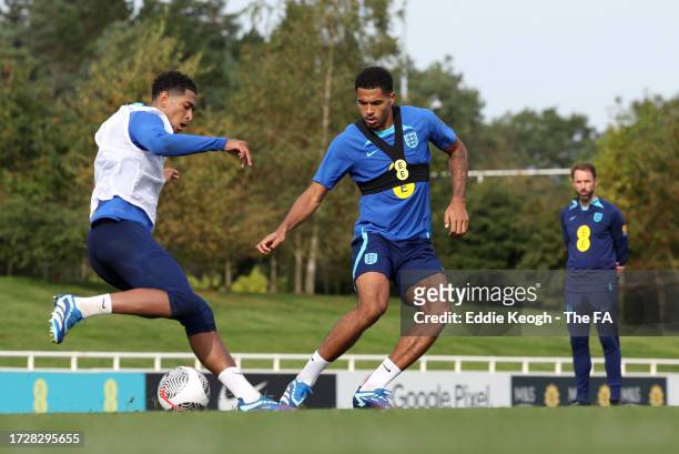 Jude Bellingham and Levi Colwill of England battle for possession during a training session at St George's Park on October 10, 2023 in Burton upon...