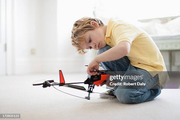 boy playing with toy helicopter - toy helicopter stock pictures, royalty-free photos & images