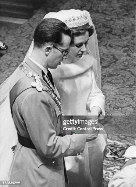 King Baudouin of Belgium places the ring on the finger of Queen Fabiola of Belgium during their wedding ceremony at the Cathedral of St. Michael and...