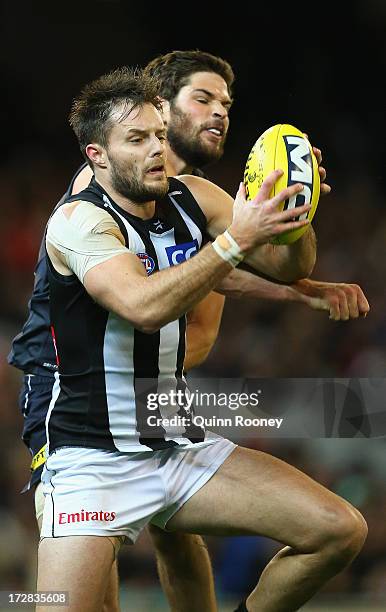 Nathan Brown of the Magpies marks infront of Levi Casboult of the Blues during the round 15 AFL match between the Carlton Blues and the Collingwood...