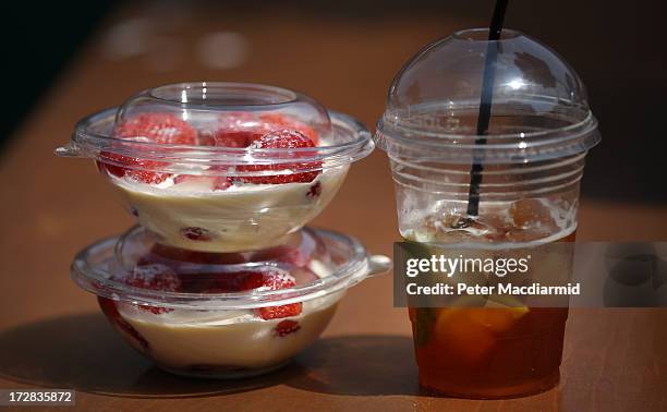 Strawberries and cream with a glass of Pimm's are purchased on day eleven of the Wimbledon Lawn Tennis Championships at the All England Lawn Tennis...