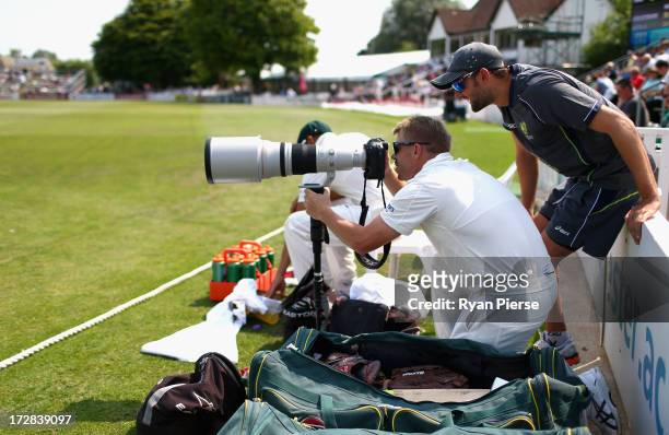 David Warner of Australia takes photos from the boundary during day three of the Tour Match between Worcestershire and Australia at New Road on July...