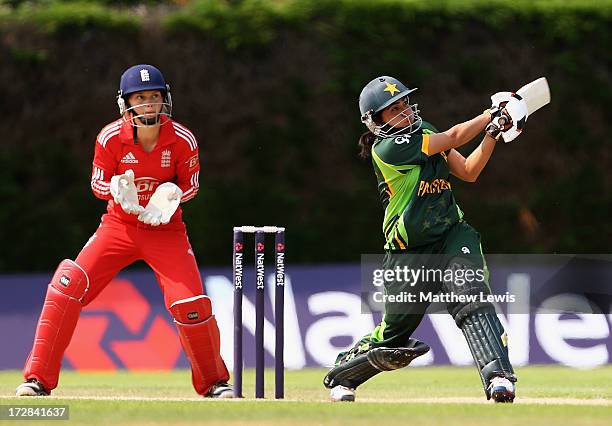 Sana Mir of Pakistan hits the ball towards the boundary, as Amy Jones of England looks on during the 2nd NatWest Women's International T20 match...