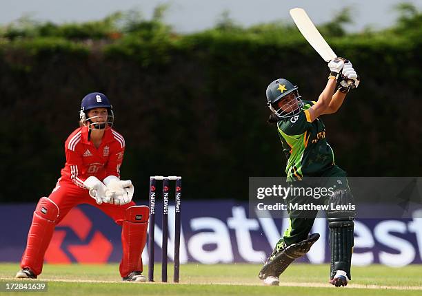 Sana Mir of Pakistan hits the ball towards the boundary, as Amy Jones of England looks on during the 2nd NatWest Women's International T20 match...