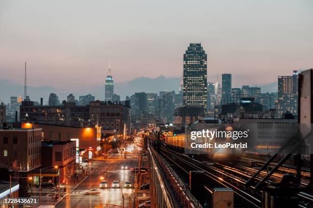 die skyline von new york bei sonnenuntergang von einer u-bahn-station aus gesehen - queens stock-fotos und bilder