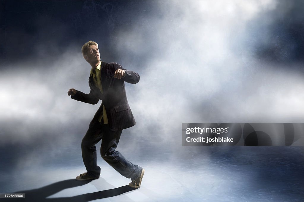 Man in a suit looking up in a ready-to-run stance