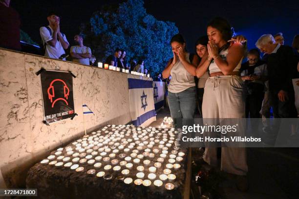 Participants pray before lit candles during a vigil organized by the Lisbon Jewish Community for Israeli victims of the Hamas attack on October 10 in...