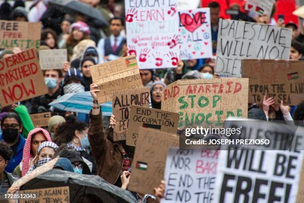 People hold signs during a rally in support of Palestinians at Copley Square in Boston, Massachusetts on October 16, 2023. Israel warned October 16,...