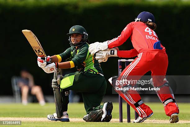 Nida Rashid of Pakistan pulls the ball towards the boundary, as Amy Jones of England looks on during the 2nd NatWest Women's International T20 match...